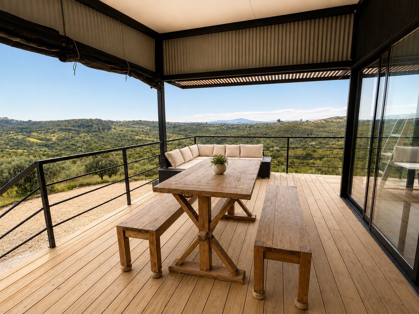 Galería techada con mesa de madera y sillones frente al valle